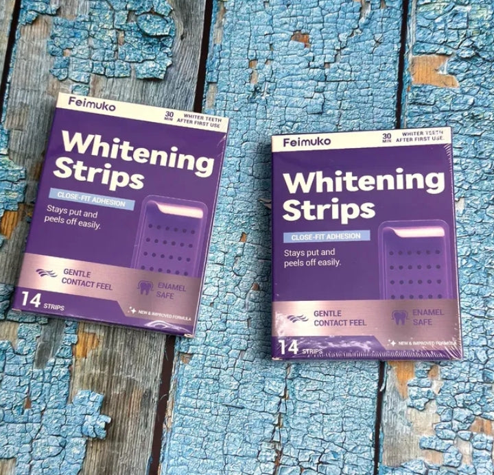 Two packages of Feimuko Whitening Strips on a textured blue and brown surface