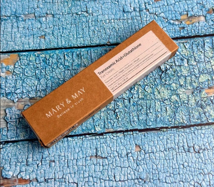 Brown box with 'MARY & MAY' branding on a blue, textured surface