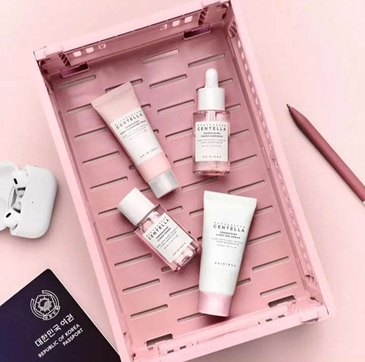 Set of skincare products on a pink tray with a pink background

