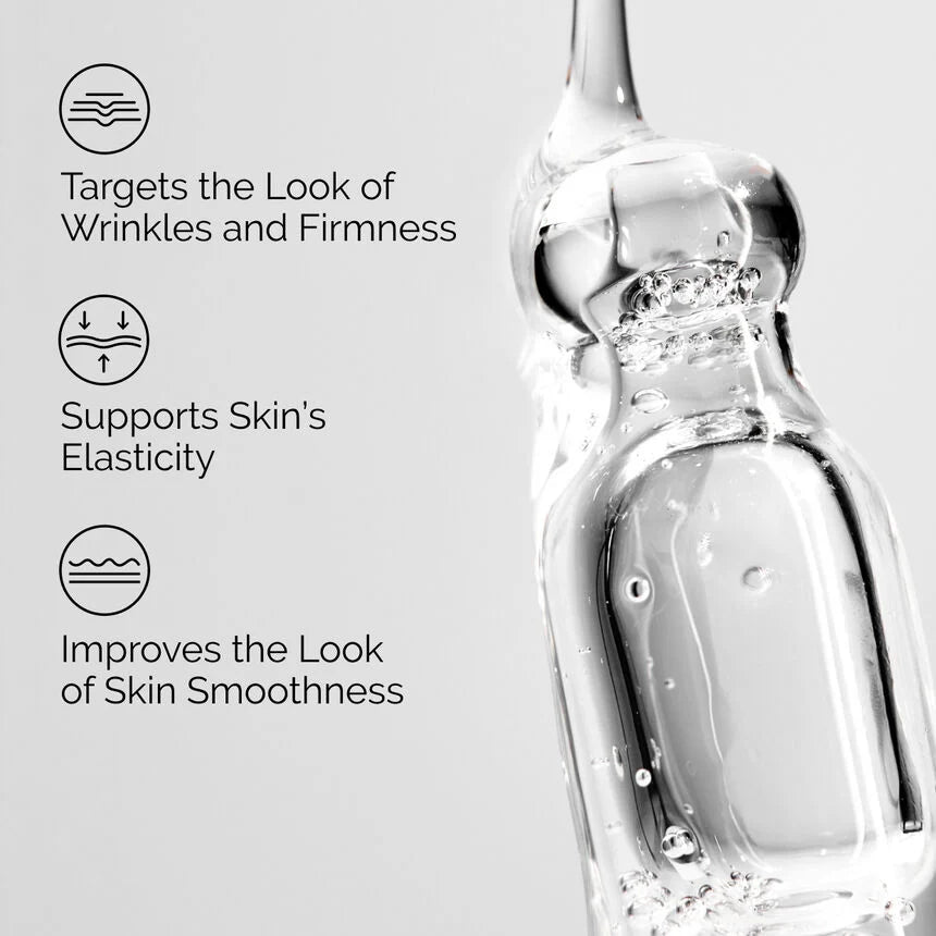 Skincare serum bottle with text highlighting benefits on a light gray background