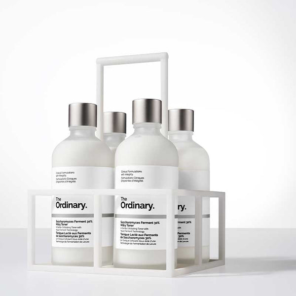Set of skincare products from 'The Ordinary' in a white display stand on a light background