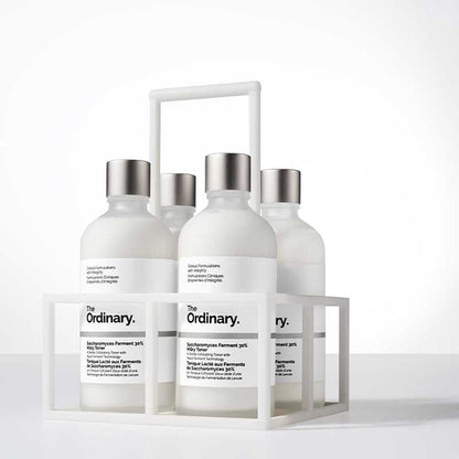 Set of skincare products from 'The Ordinary' in a white display stand on a light background